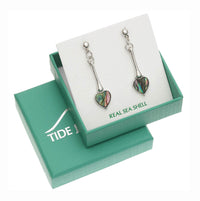 A pair of silver dangle earrings with heart-shaped iridescent abalone shell pendants, presented on a white card inside a teal gift box labeled TIDE.
