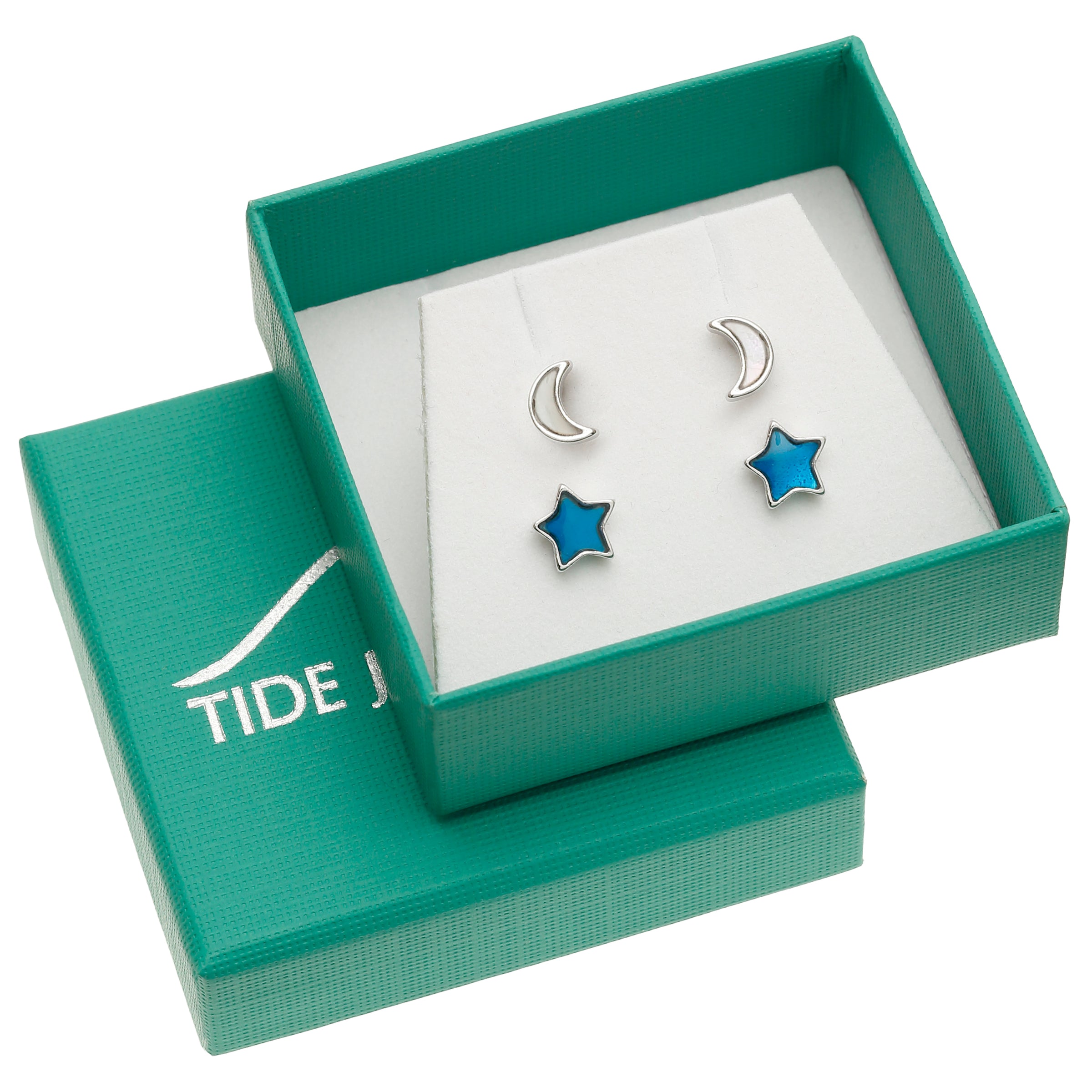 A pair of silver-toned stud earrings displayed in an open teal gift box. One earring is a crescent moon and the other is a five-point star with bright blue enamel inlay.